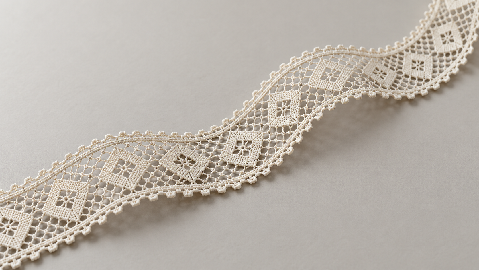 Illustrative geometric lace trim arranged diagonally against a warm neutral background