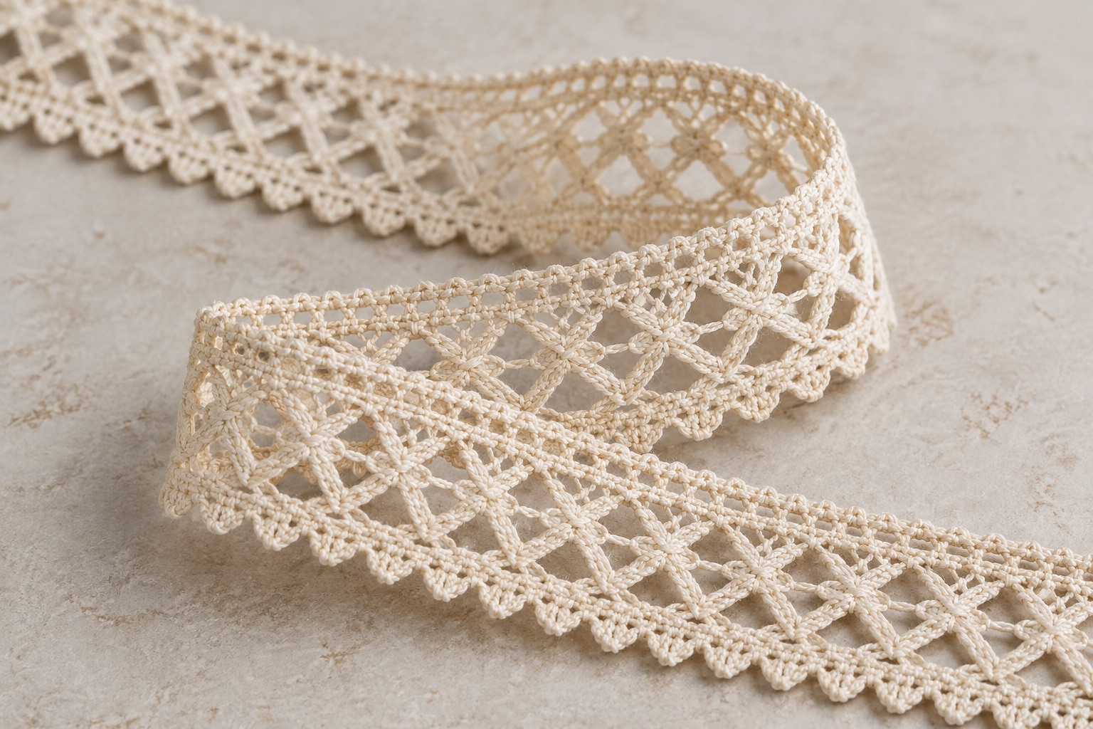 Illustrative natural ecru Torchon lace trim arranged in a loop