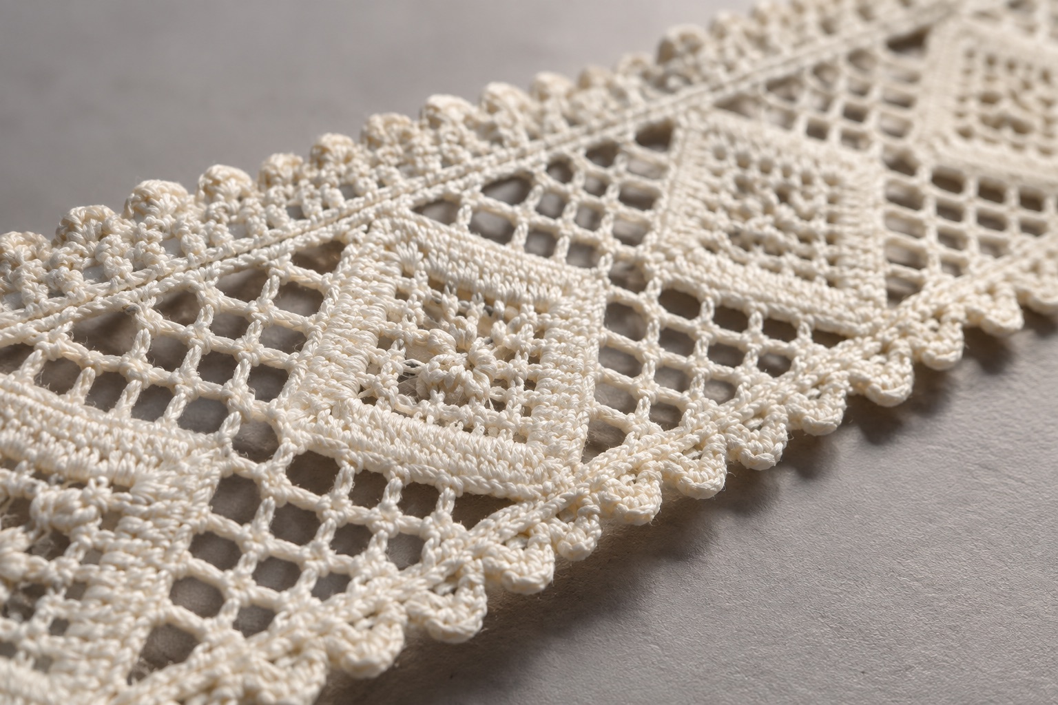 Illustrative side detail showing the edge and thread texture of lace